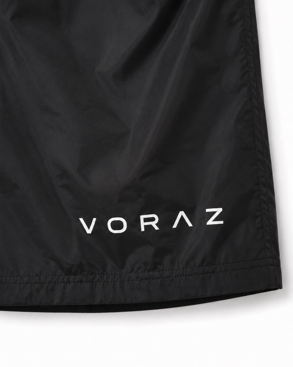 Detalhe da assinatura VORAZ branca e do acabamento da Bermuda Essential preta